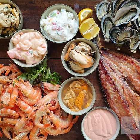 Assorted seafood including oysters, shrimp, and dried fish on a wooden surface with 'Seafood Bazaar' branding.